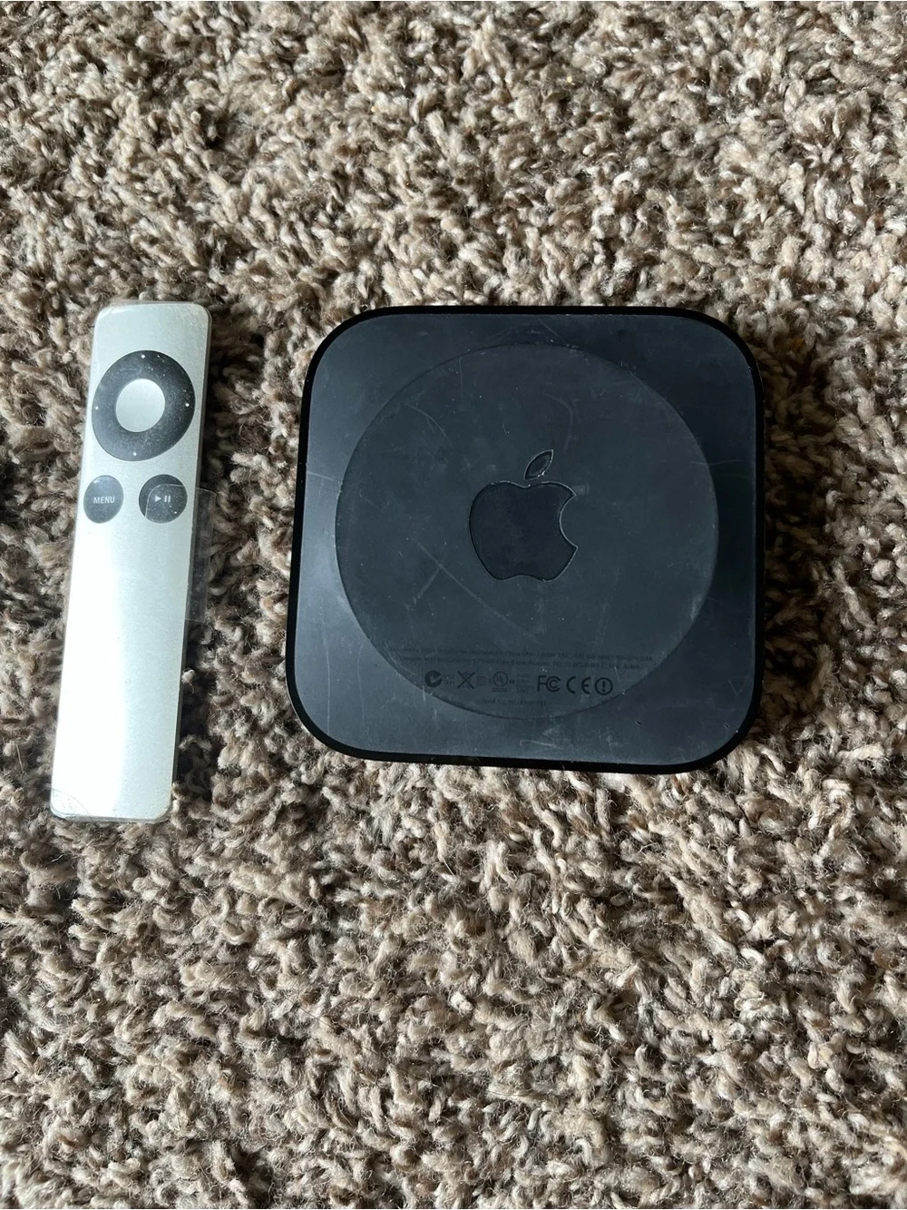 Apple TV with Silver Remote and Black Power Cable